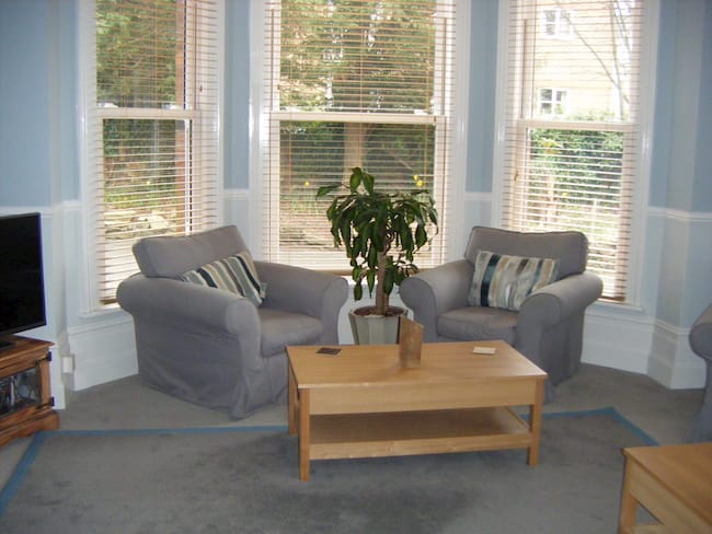 Two grey armchairs in a bay window