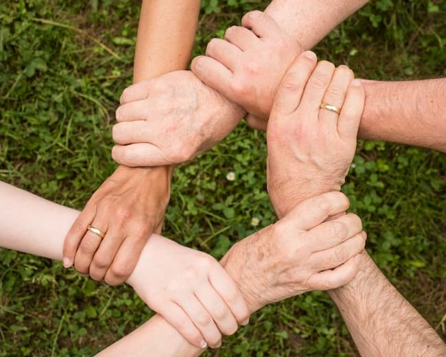 Hands clasped in a circle representing helping each other